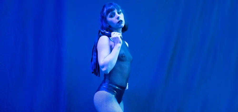 Mistress Obelia holding flogger during BDSM domination session